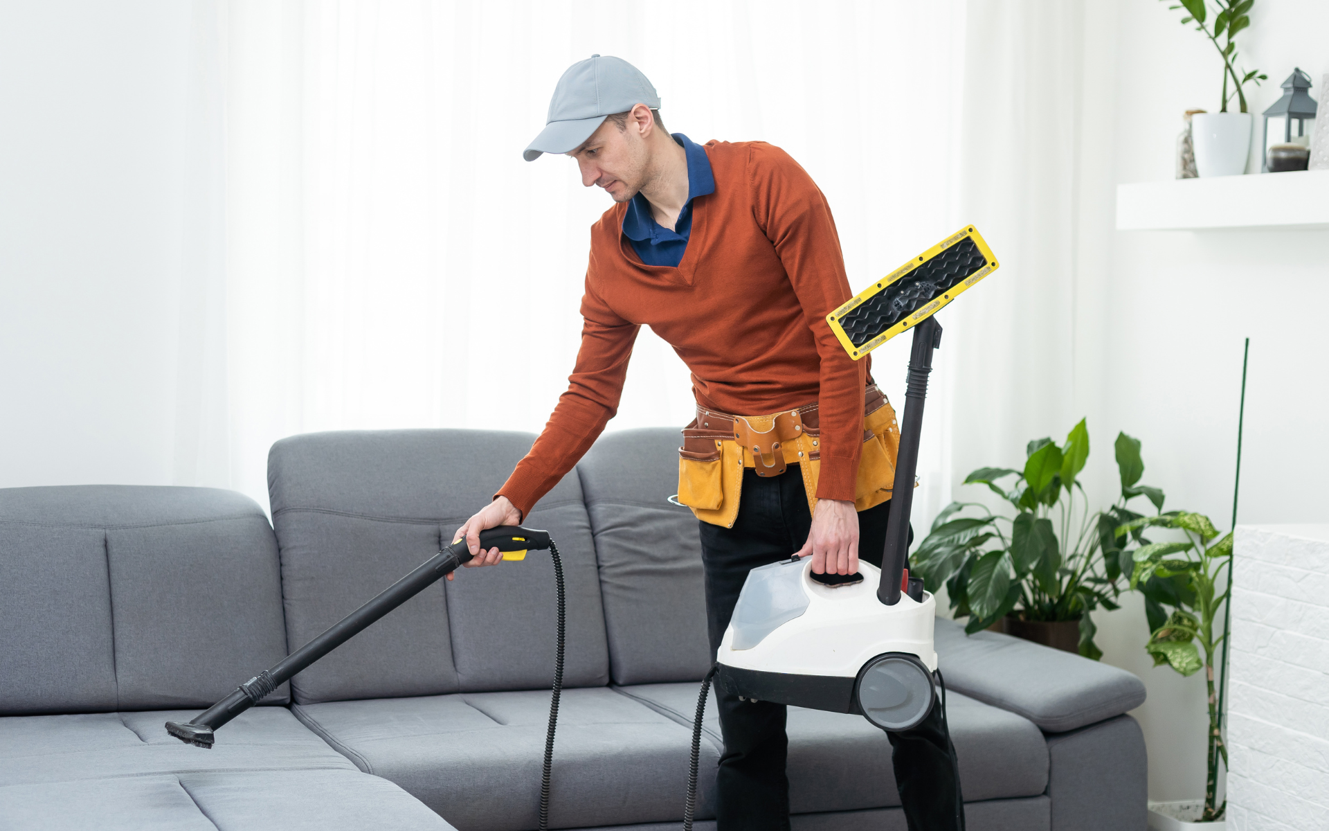 Male cleaner cleaning the sofa